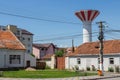 A view of a wooden bench and a water tower next to a historic house in the town of Greenbow. Transylvania. Romania Royalty Free Stock Photo