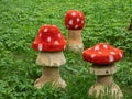 View of wooden decorations made prom cut tree trunk and carved in shape of toadstool as fly agaric painted with red cap and white Royalty Free Stock Photo