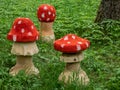 View of wooden decorations made prom cut tree trunk and carved in shape of toadstool as fly agaric painted with red cap and white Royalty Free Stock Photo