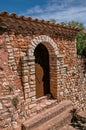 View of wooden door and wall and arch in stone under a sunny blue sky, in Roussillon. Royalty Free Stock Photo