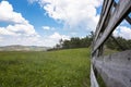 View of the wooden fence, meadow and amazing blue sky Royalty Free Stock Photo