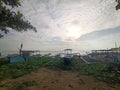 View of a wooden fishing boat on the beach with sunlight and clouds in the background Royalty Free Stock Photo