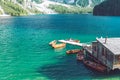 view of wooden house on water with pier and boats lake in dolomites mountains Royalty Free Stock Photo