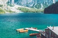 view of wooden house on water with pier and boats lake in dolomites mountains Royalty Free Stock Photo