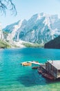 view of wooden house on water with pier and boats lake in dolomites mountains Royalty Free Stock Photo