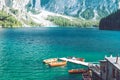 view of wooden house on water with pier and boats lake in dolomites mountains Royalty Free Stock Photo