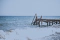 View of a wooden pier and seascape with running waves