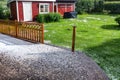 View at wooden terrace and green garden with hail stones during hailstorm from sky with sunlight