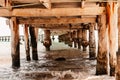 View of wooden under pier bridge over waves of sea