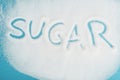 View of word sugar made on sprinkled white sugar crystals on blue surface