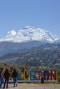 View of the words Callejon with some tourists and in the background the snowy Huascaran in Carhuaz.