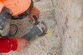 View of a worker at a construction site working with a rock-drill and digging