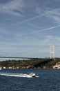 View of a yacht passing on Bosphorus and FSM bridge in Istanbul. It is a sunny summer day. Royalty Free Stock Photo