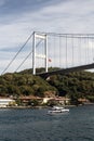 View of yacht passing on Bosphorus by Kanlica neighborhood on Asian side of Istanbul. FSM bridge is in the background.