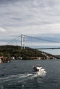 View of yacht passing on Bosphorus by Kanlica neighborhood on Asian side of Istanbul. FSM bridge is in the background.