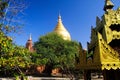 View on yard of buddhist temple with trees and golden pagoda