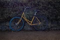 View of a yellow bicycle parked by a bush fence