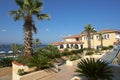 View of the yellow building, the blue sea and green palm trees in the hotel, Greece Royalty Free Stock Photo