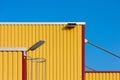 View of a yellow container of Hazardous Material goods with a lamp against a light sky