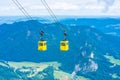 View of mountains and yellow Seilbahn cable car gondolas from Zwolferhorn mountain