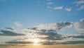 View of yellow sun setting in the orange sky with dark clouds. Timelapse. Royalty Free Stock Photo