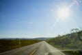 View on yellow sunset and clouds from the car front window and the glare on the glass. Driving car during sunshine in the tundra Royalty Free Stock Photo