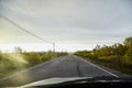 View on yellow sunset and clouds from the car front window and the glare on the glass. Driving car during sunshine in the tundra Royalty Free Stock Photo