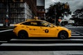 View of yellow Tesla Taxi driving by with the New York urban background