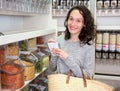 Young attractive woman shooping looses spices at the grocery Royalty Free Stock Photo