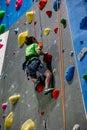 Young boy climbing up on practice wall in indoor rock gym Royalty Free Stock Photo