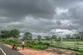 View of young boys sitting on the side of the road, farmhouse with baobabs as background Royalty Free Stock Photo