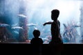 View of young kids watching fishes in aquarium Royalty Free Stock Photo