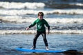 Young little boy on beach taking surfing lessons