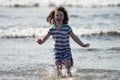 Young little girl on beach playing in the surf