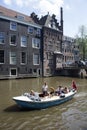 View of young people riding a small, blue, open boat