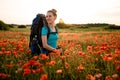 View of young smiling woman with backpack on poppy field who turned back Royalty Free Stock Photo