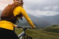 View of a young woman sitting on a mountain bike high in the mountains against the backdrop of epic rocks in the evening Royalty Free Stock Photo