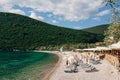 View of the Zanjice beach on the Lustica peninsula in Montenegro against the backdrop of green mountains. Tourists rest