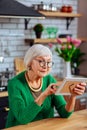 Septuagenarian lady viewing photo of her family in frame