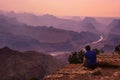 Man sitting looking out over the Southern Rim of the Grand Canyon