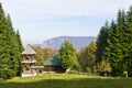 Viewpoint on a landscape of mount Bobija, meadow in front of an old wooden church surrounded by tall fir trees Royalty Free Stock Photo