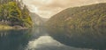 Beautiful foggy mountain lake with overcast sky. Vintage filter style. Peaceful nature landscape, tranquil lake water Royalty Free Stock Photo