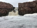 The Big Sioux River flows over rocks in Sioux Falls South Dakota with views of wildlife, ruins, park paths, train track bridge, tr Royalty Free Stock Photo