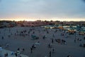 Views of the food market and shops of the Jemaa el Fna square in Marrakech with people at dusk