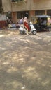 Views of Indian street, younger female driving scooter