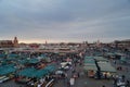 Views of the food market and shops of the Jemaa el Fna square in Marrakech with people at dusk
