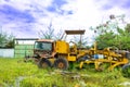 Views from the multiple kind of vehicles broken down focused on an old tractor with the plants start to grow around them, at a