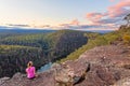 Female sits rock with views over Nepean River and Blue Mountains