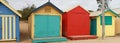 Views of rows of colourful beach bright painted summer holiday bathing box`s along a sandy beach on a sunny day, Brighton beach,