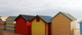 Views of rows of colourful beach bright painted summer holiday bathing box`s along a sandy beach on a sunny day, Brighton beach,